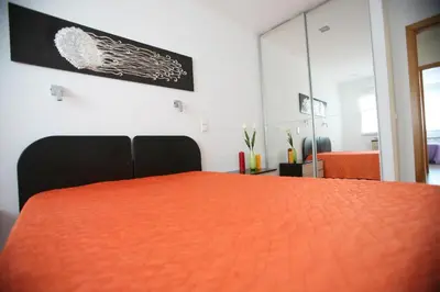 a bedroom with a bed with an orange bedspread at Luz House in Luz