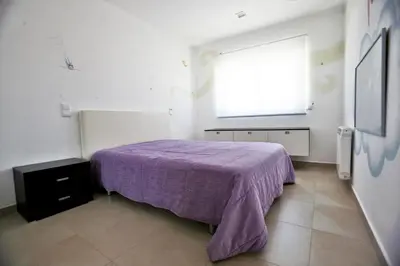 a bedroom with a purple bed and a window at Luz House in Luz