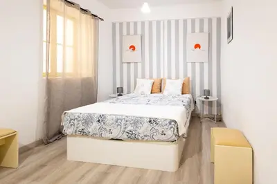 a white bedroom with a bed and a window at The House in Funchal