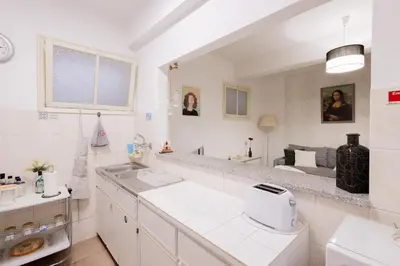 a white kitchen with a sink and a mirror at The House in Funchal