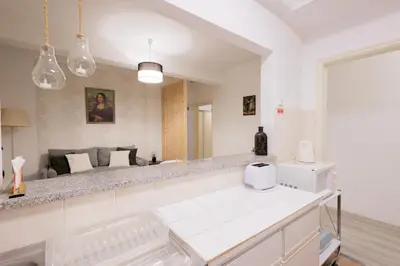 a kitchen with a white counter and a living room at The House in Funchal
