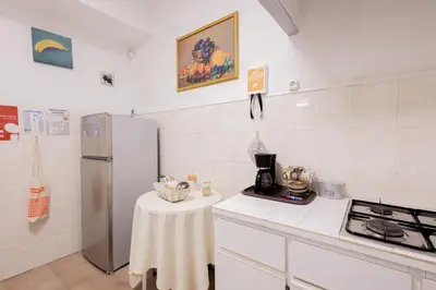 a kitchen with a refrigerator and a table in it at The House in Funchal