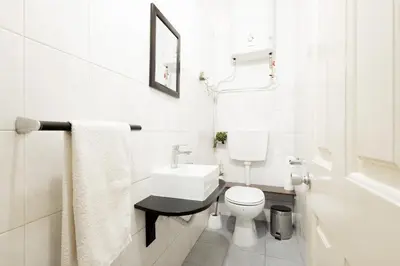 a white bathroom with a toilet and a sink at The House in Funchal