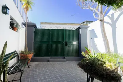 a green gate of a house with a bench at The House in Funchal