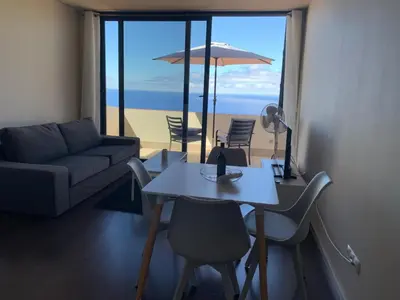 a living room with a couch and a table with chairs at Villa Pinheira I in Calheta