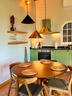 a kitchen with a wooden table with four chairs around it at Blooming Botanic Houses in Estreito da Calheta