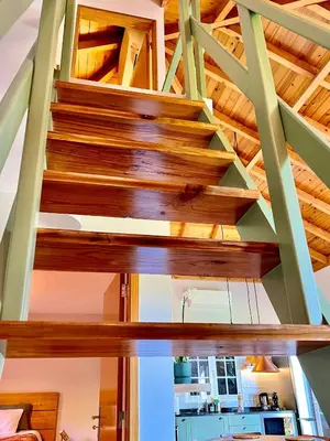 a staircase in a house with wooden ceilings at Blooming Botanic Houses in Estreito da Calheta