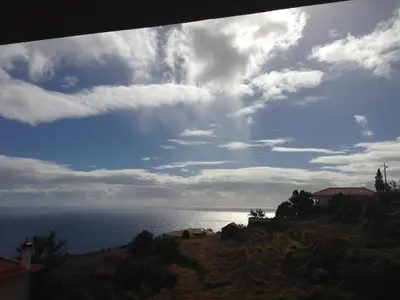 a view of the ocean under a cloudy sky at Blooming Botanic Houses in Estreito da Calheta