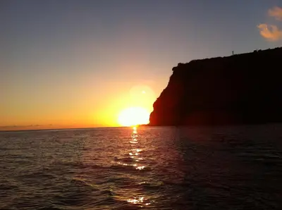 a sunset from a boat in the ocean at Blooming Botanic Houses in Estreito da Calheta