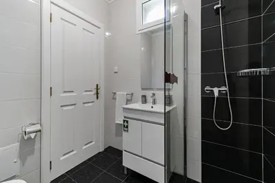 a white bathroom with a sink and a shower at Casa da Aldeia by An Island Apart in Câmara de Lobos