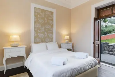 a bedroom with a large white bed and a window at Casa da Aldeia by An Island Apart in Câmara de Lobos