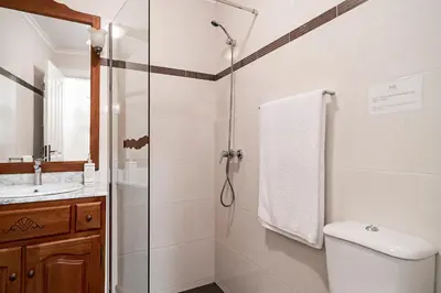 a bathroom with a shower and a toilet and a sink at Casa da Aldeia by An Island Apart in Câmara de Lobos