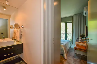 a bathroom with a sink and a bed and a mirror at Apartamento Astrolab in Funchal