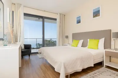 a bedroom with a large bed and a large window at Villa Enjoy - by LovelyStay in Lombo da Velha