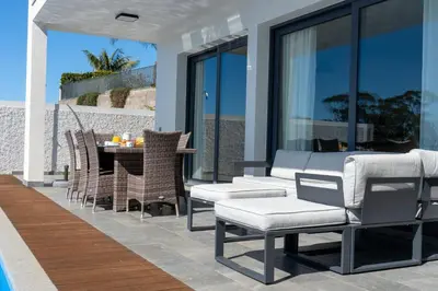 a bedroom with a bed and a large window at Villa Enjoy - by LovelyStay in Lombo da Velha
