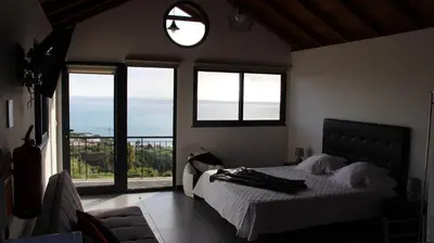 a bedroom with a bed with a view of the ocean at Adega do Avô 2 Madeira in Estreito da Calheta