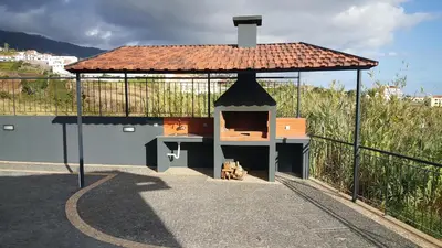 a pizza oven with a roof on top of a building at Adega do Avô 2 Madeira in Estreito da Calheta