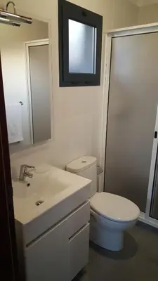 a bathroom with a toilet and a sink and a mirror at Adega do Avô 2 Madeira in Estreito da Calheta