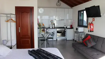 a living room with a couch and a kitchen at Adega do Avô 2 Madeira in Estreito da Calheta