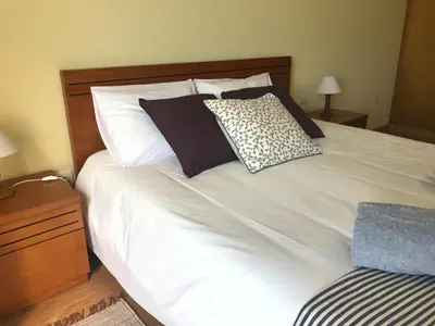 a large white bed with black and white pillows at Atlantic Rose in Calheta