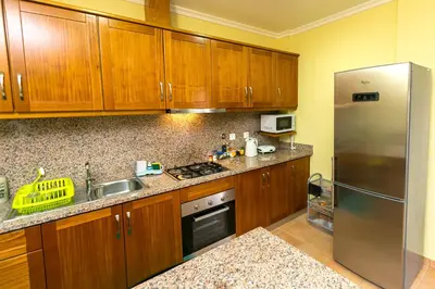 a kitchen with wooden cabinets and a stainless steel refrigerator at Atlantic Rose in Calheta