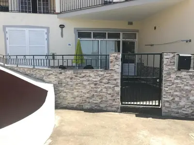 a house with a stone wall and a balcony at Atlantic Rose in Calheta