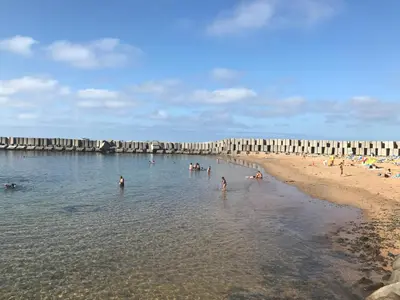 a group of people in the water at the beach at Atlantic Rose in Calheta