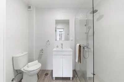 a white bathroom with a toilet and a sink at Funchal City Apartments in Funchal