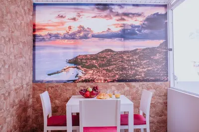 a dining room with a table and chairs with a painting on the wall at Funchal City Apartments in Funchal