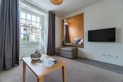 a living room with a table and a tv at Welcome Madeira Apartments by Wanderlust Madeira in Funchal