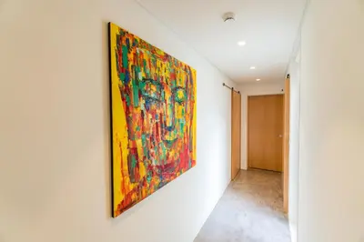 a painting hanging on a wall in a hallway at Welcome Madeira Apartments by Wanderlust Madeira in Funchal