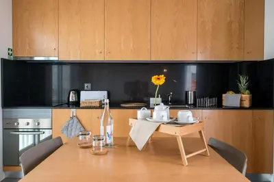 a kitchen with a wooden table with chairs and a dining room at Welcome Madeira Apartments by Wanderlust Madeira in Funchal