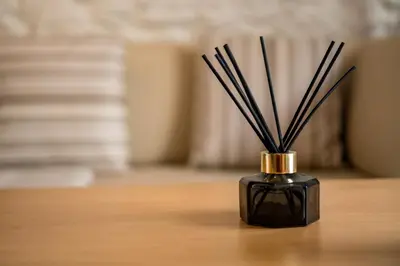 a black vase with sticks in it on a table at Welcome Madeira Apartments by Wanderlust Madeira in Funchal