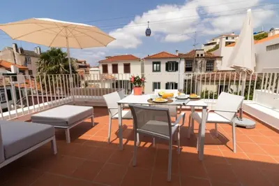 a patio with a table and chairs and an umbrella at Welcome Madeira Apartments by Wanderlust Madeira in Funchal