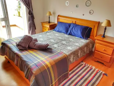 a bedroom with a bed with a colorful blanket at Falesia Apartment - Reis Magos Beach in Caniço