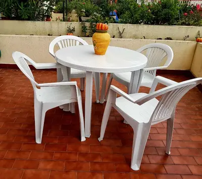 a white table and chairs with a vase on it at Falesia Apartment - Reis Magos Beach in Caniço