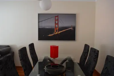 a dining room with a glass table and a golden gate bridge at Holidays Plaza in Santa Cruz