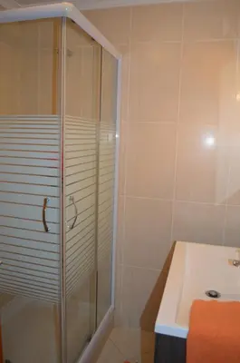 a bathroom with a glass shower and a sink at Holidays Plaza in Santa Cruz