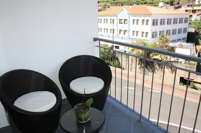 a balcony with two chairs and a table with a view at Holidays Plaza in Santa Cruz