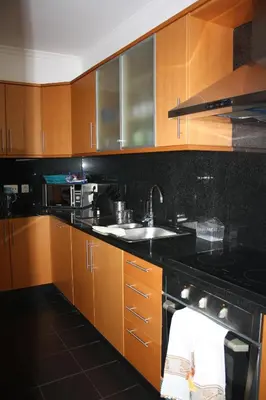 a kitchen with wooden cabinets and a sink and a stove at Holidays Plaza in Santa Cruz