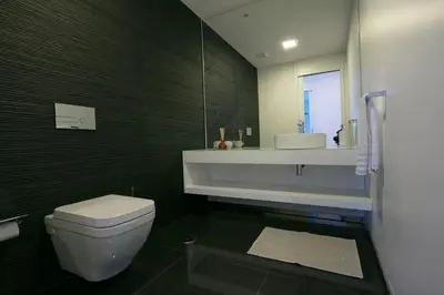a bathroom with a white toilet and a sink at Spacious luxury holiday apartment with a great view, Funchal, free wifi and parking in Funchal