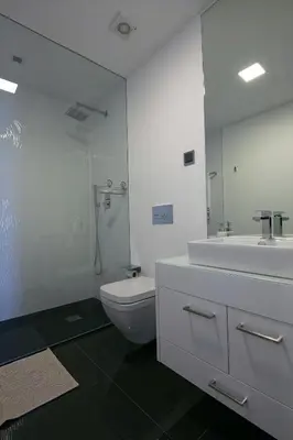 a bathroom with a toilet and a sink and a mirror at Spacious luxury holiday apartment with a great view, Funchal, free wifi and parking in Funchal