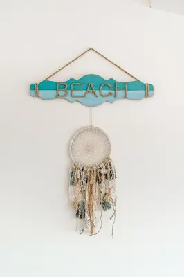 a beaded dream catcher hanging on a white wall at Romantik Villa in Salema