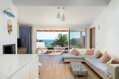 a living room with a couch and a view of the ocean at Romantik Villa in Salema