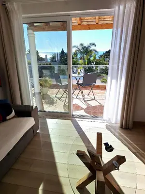 a living room with a view of a patio at Romantik Villa in Salema