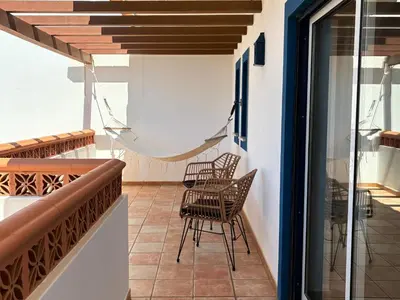 a balcony with chairs and a hammock at Aloha Burgau Guesthouse in Burgau