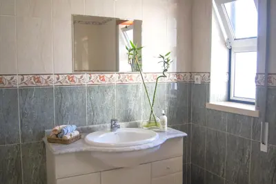 a bathroom with a sink and a mirror at Aloha Burgau Guesthouse in Burgau