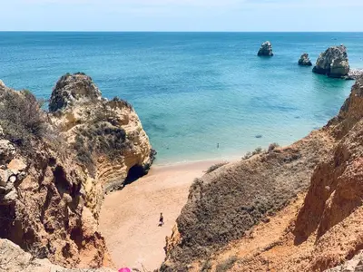 a view of a beach with rocks and the ocean at Aloha Burgau Guesthouse in Burgau