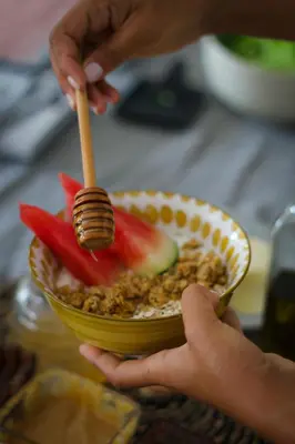 a person holding a spoon and a bowl of food at Arrifana Destination Suites in Aljezur