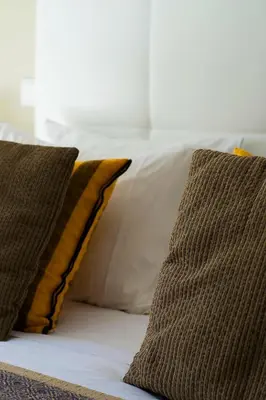 a bed with two pillows on top of it at Arrifana Destination Suites in Aljezur